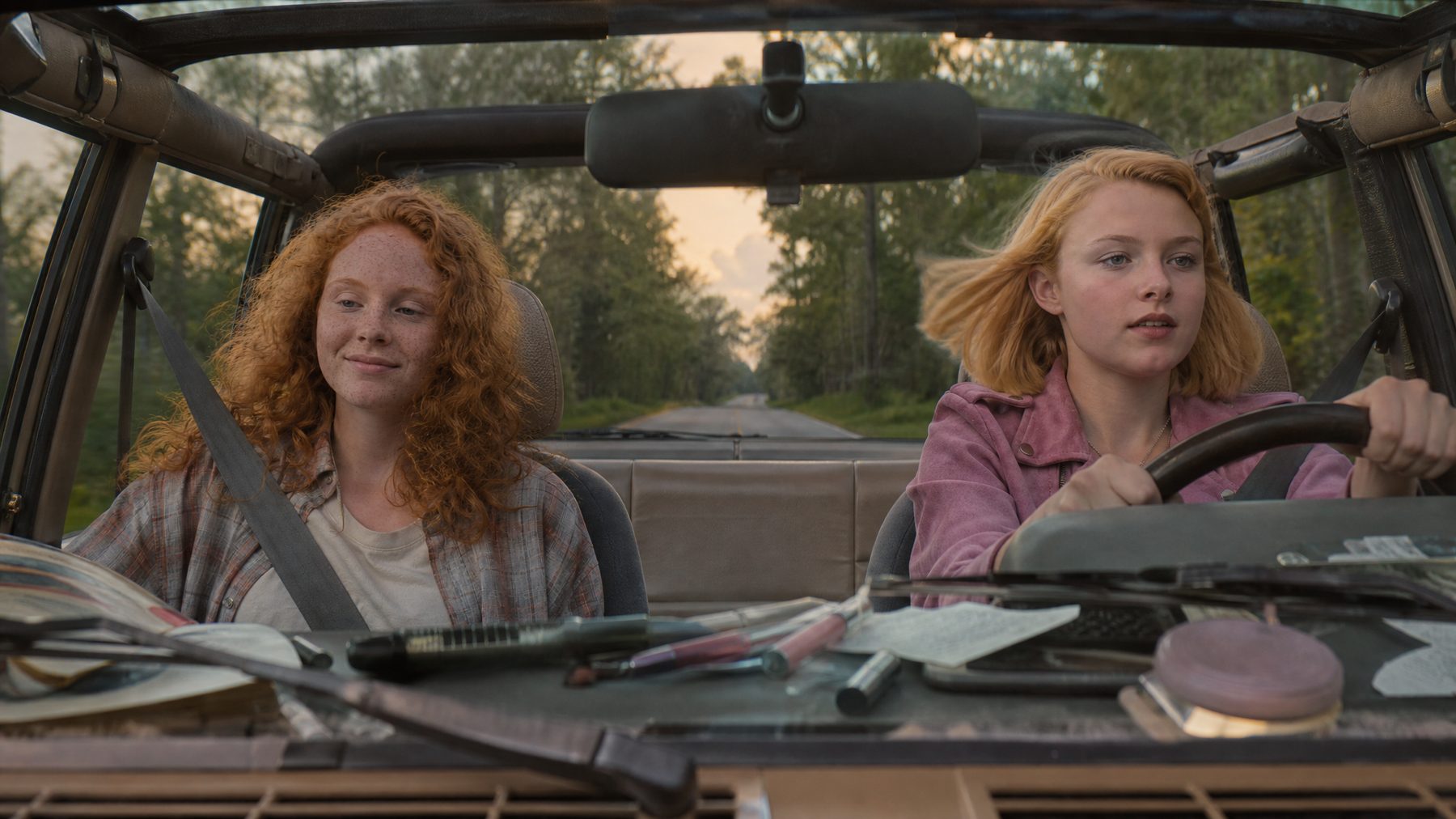 Two teenage girls in an open-top Jeep on a Florida road at dusk